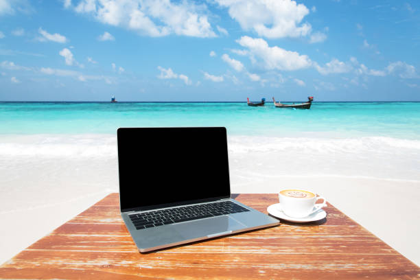 istock Laptop Computer And Coffee Cup On The Table At Seaside 1132926395