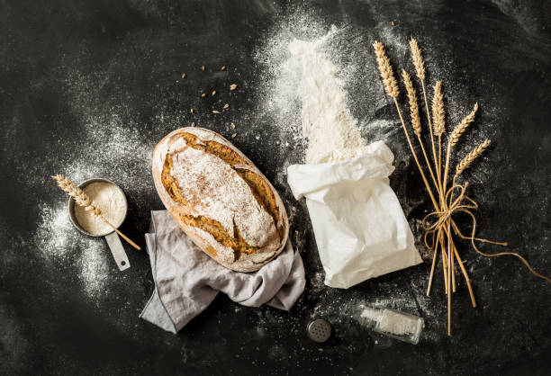 istock Bread, flour bag, wheat and measuring cup on black 1132927193