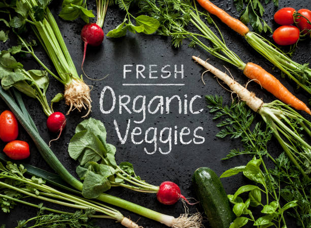 istock 'Fresh Organic Veggies' poster design. Young spring vegetables on black. 1132927393