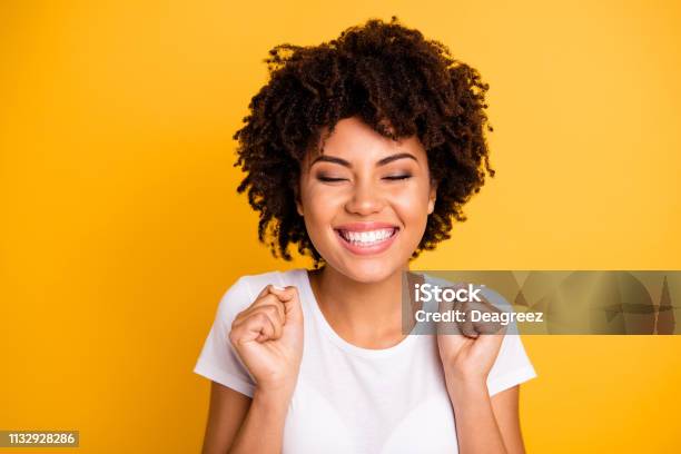Close Up Photo Beautiful Amazing She Her Dark Skin Lady Hands Arms Fists Raised Eyes Closed Great Big Win Competition Wear Casual White Tshirt Isolated Yellow Bright Vibrant Vivid Background Stock Photo - Download Image Now