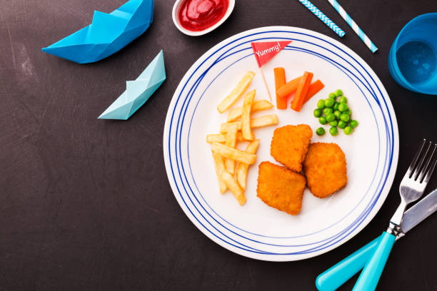 istock Kid's meal (dinner) - fish, chips, carrot and green peas 1132930365