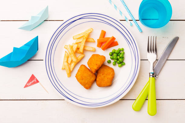 istock Kid's meal (dinner) - fish, chips, carrot and green peas 1132930367