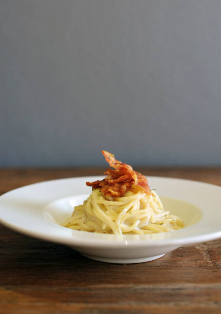 istock Delicious spaghetti carbonara with bacon on wooden table 1132932563
