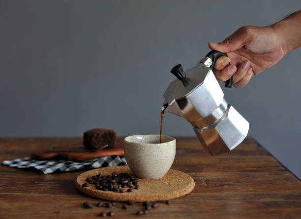 Moka pot coffee maker and coffee cup, steel italian espresso coffee pot stock photo