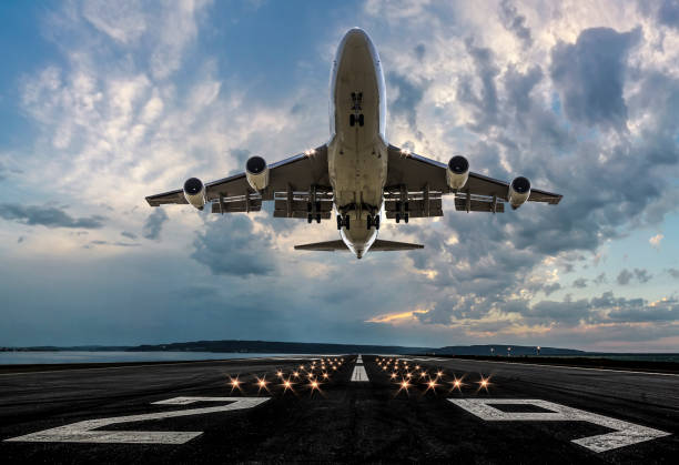 Passenger airplane taking off at sunset stock photo