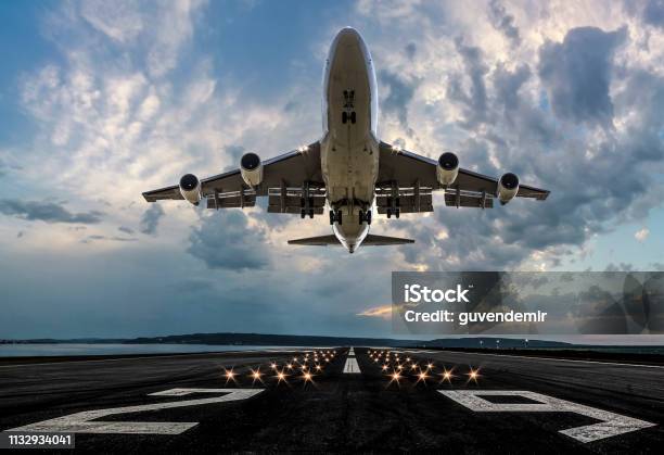 Passenger Airplane Taking Off At Sunset Stock Photo - Download Image Now - Airplane, Taking Off - Activity, Commercial Airplane