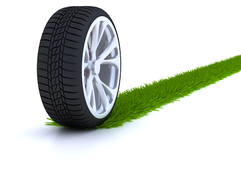 Car wheel with grass trail isolated in white background