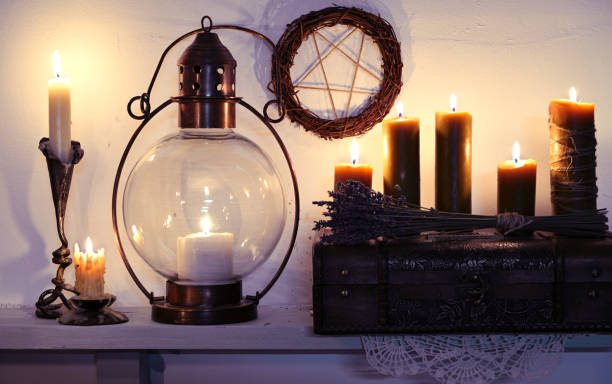 istock Old lamp, burning candles and lavender bunch with pentagram on wall 1132935758
