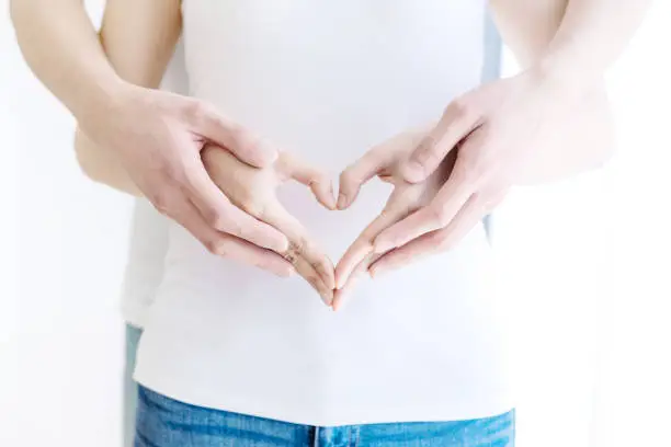 Photo of Couple hands making heart shape.