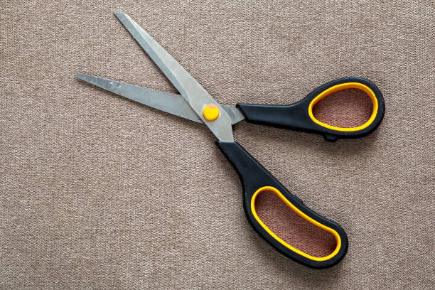 istock Close-up of sharp steel metal scissors isolated on light cloth copy space background. Household equipment, office or school tools. 1132939726