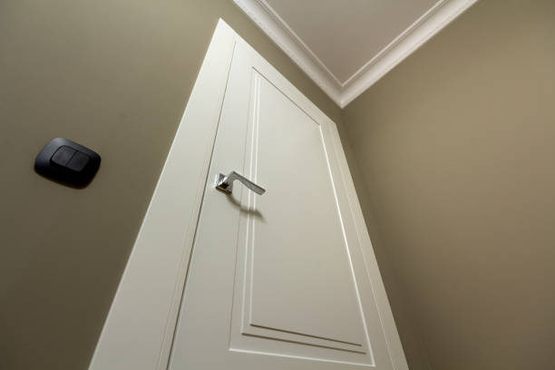 istock Apartment after renovation interior. White door with metal handle, light walls and ceiling, angle view. 1132939740