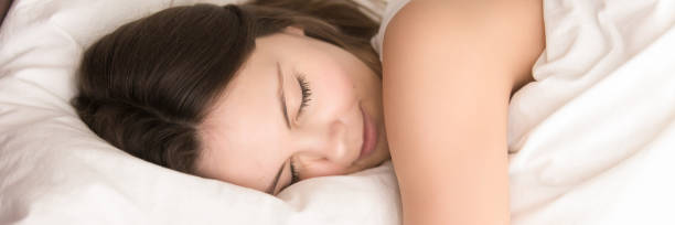 close up woman sleeping lying in bed panoramic image - eyes narrowed imagens e fotografias de stock