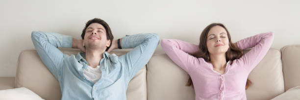 istock Horizontal image of couple with closed eyes resting on couch 1132941023