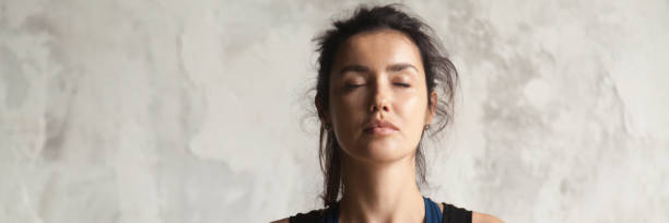 Horizontal image beautiful woman face with closed eyes practicing yoga Horizontal photo beautiful woman face with closed eyes practicing yoga breath meditate feels calmness. Physical and mental healthcare concept, banner for website header design with copy space for text relieved face stock pictures, royalty-free photos & images