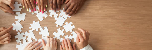 istock Above panoramic view hands of diverse people assembling jigsaw puzzle 1132941118