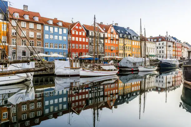 Colourful houses and sailingboats reflecting in the calm canal in wonderful Copenhagen, February 16, 2019