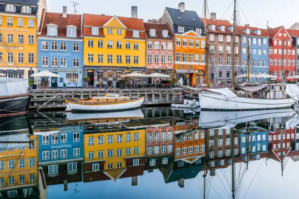 Reflections of colourful houses and sailingboats in the calm canal of wonderful Copenhagen, February 16, 2019