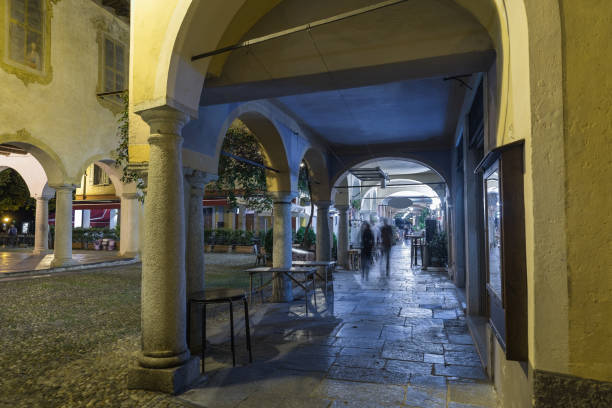 Beautiful square at night in the historic center with paving stone arcade. Picturesque Italian village, Orta San Giulio (square Motta), on lake Orta, northern Italy\nOrta San Giulio is famous for  for the historical center, traditional shops, typical restaurants, old houses, alleys in stone and pebbles; for San Giulio island or isola San Giulio, a little island with very picturesque buildings and alleys. Another attraction is the Sacro Monte di Orta, on the hill behind the village, entirely dedicated to a saint, the 20 chapels that compose it depict episodes of the life and miracles of St. Francis of Assisi. Piedmont, province of Novara