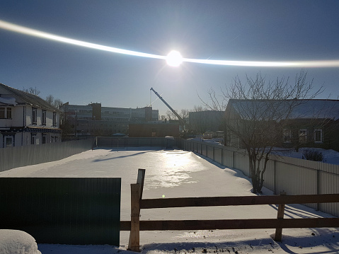 beautiful construction crane on a construction site on the background of the sun in winter