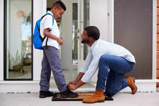 istock Father Tying Sons Shoelaces As He Leaves For School 1132948818