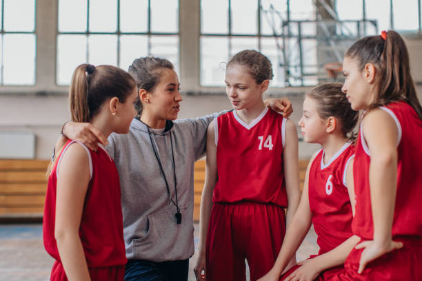 istock Coach standing with basketball team 1132949211