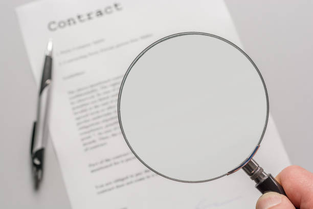 contract with empty magnifying glass as a template for further processing - fine print imagens e fotografias de stock