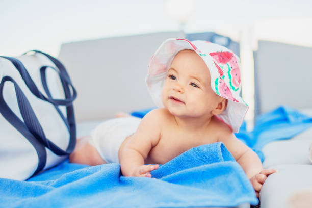 petite fille mignonne dans un chapeau de soleil sur un salon méridienne de plage - outdoor chair furniture travel vacations photos et images de collection