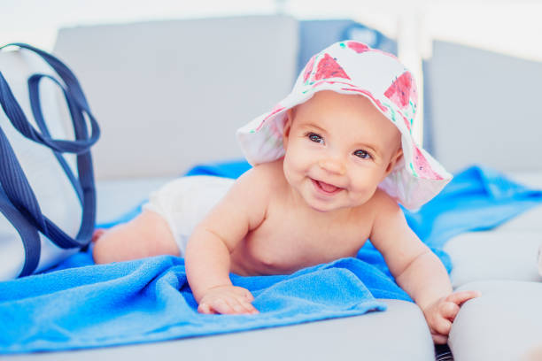 ビーチ長椅子に太陽の帽子でかわいい女の赤ちゃん - chaise longue 写真 ストックフォトと画像