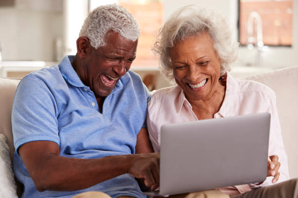 istock Senior Couple Sitting On Sofa At Home Together Using Laptop 1132950243