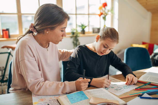 istock Private teacher helping girl doing homework 1132950558