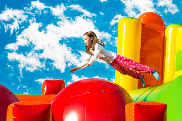 膨らませた城でジャンプする女の子 - playground cute baby blue ストックフォトと画像