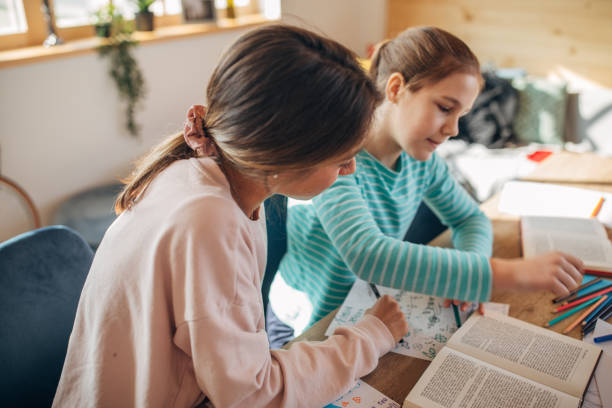 istock Private teacher helping girl doing homework 1132950873