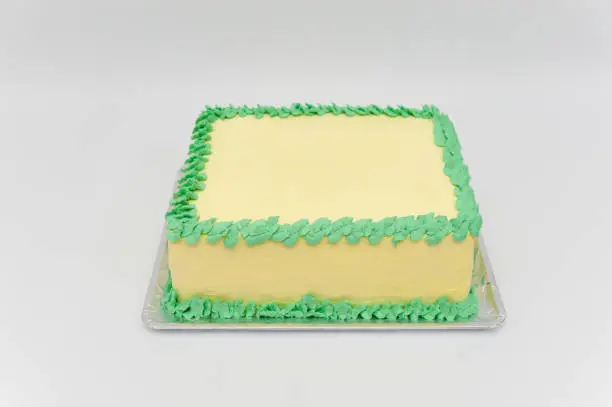 Birthday cake with green and yellow colors. Isolated on white background. Horizontal image. Front view.