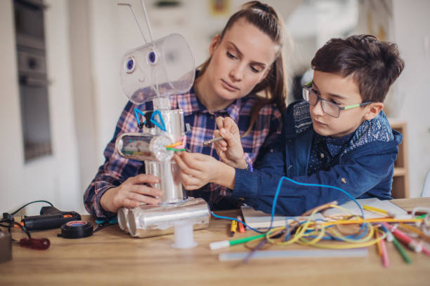 istock Boy making robot of recycling material for school project with his older sister 1132952475