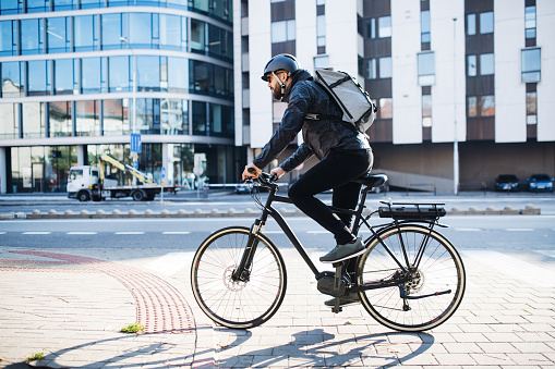 Mensajero masculino con bicicleta entregando paquetes en la ciudad. Copiar espacio. photo