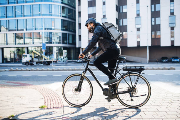 도시에서 패키지를 제공 하는 자전거와 남성 택배. 복사 공간. - bicycle 뉴스 사진 이미지