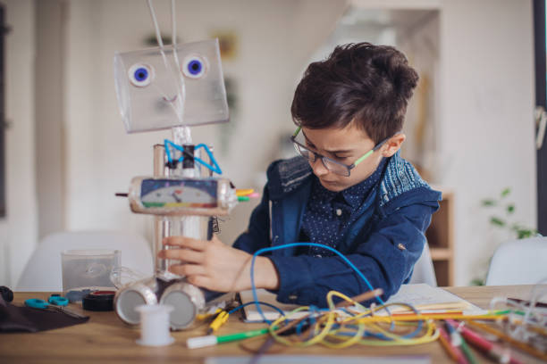 istock Boy making robot toy of recycling material 1132953721