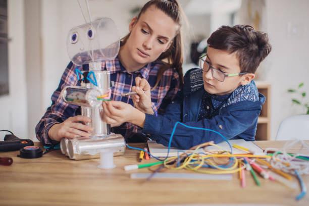 istock Boy making robot toy of recycling material for school project 1132953904