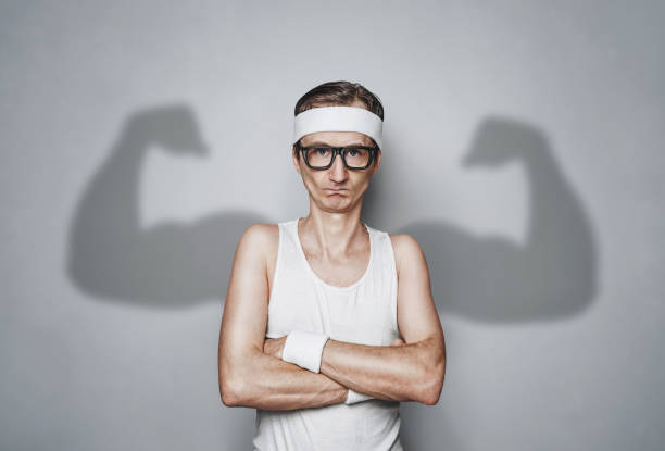 funny sport nerd with large shadow arms - flexing muscles fotos imagens e fotografias de stock