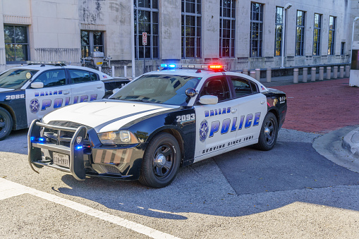 Police car on traffic duty in downtown Dallas. People are pictured in the background