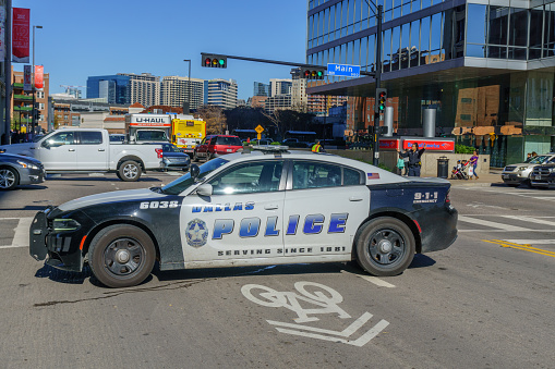 Police car on traffic duty in downtown Dallas. People are pictured in the background