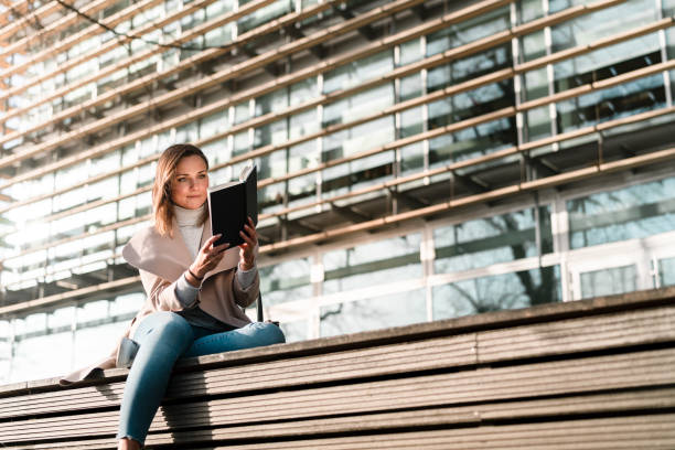 istock Female student is reading a book on campus 1132957887