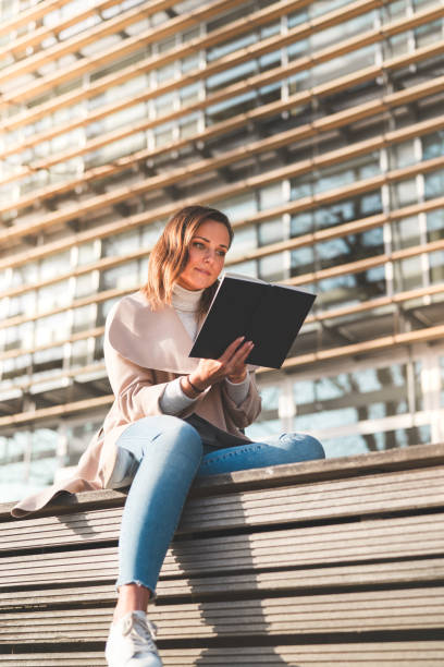 Female student is reading a book on campus