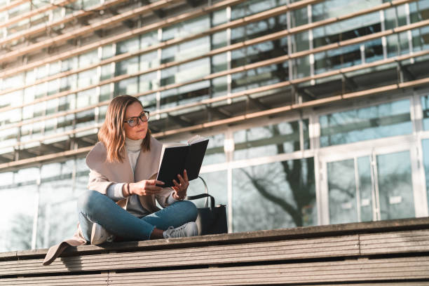 istock Female student is reading a book on campus 1132957907