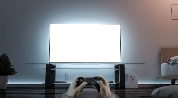 Photo of Playing videogame with joystick near blank white tv screen mockup