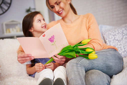 Mom and her daughter with greeting card celebrating Mother's Day