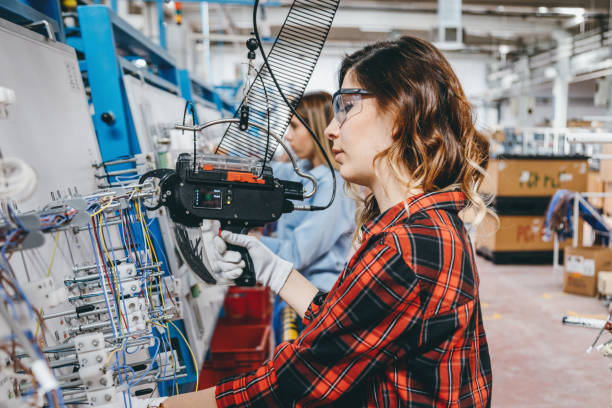 istock Female industrial worker using cable tie tool at factory 1132961658