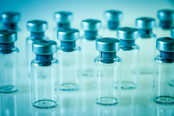 istock Vaccine glass bottles on blue background 1132962132