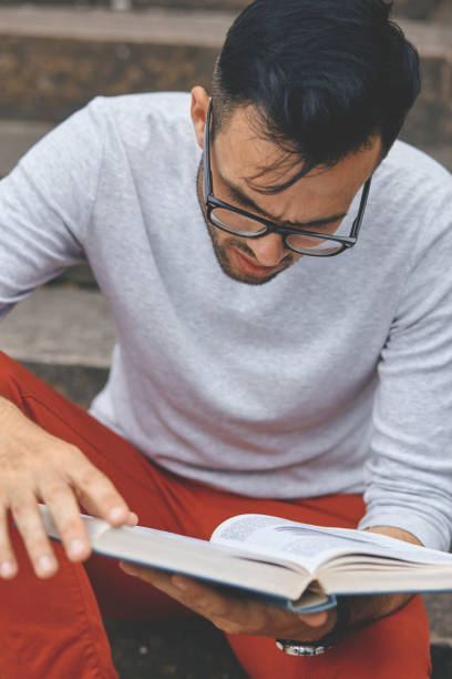 istock Young man reading a book in the campus 1132964257