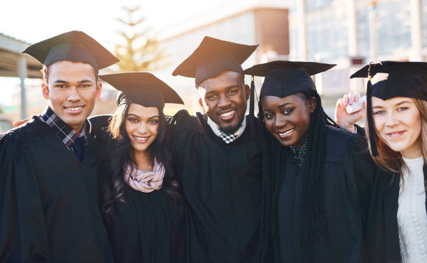 We’re ready to go change the world Portrait of a group of students standing together on graduation day ceremonial robe stock pictures, royalty-free photos & images